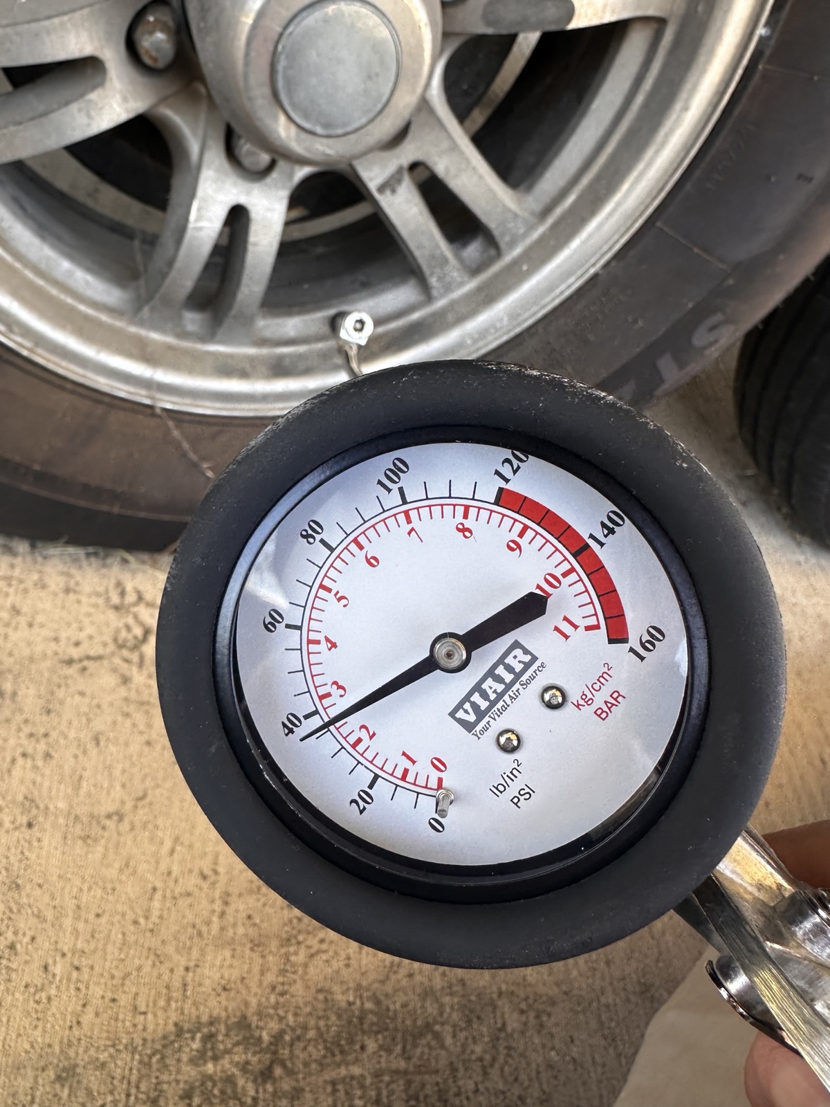 Pressure gauge reading trailer tire at pre-haul inspection — Mission Ready RV Services