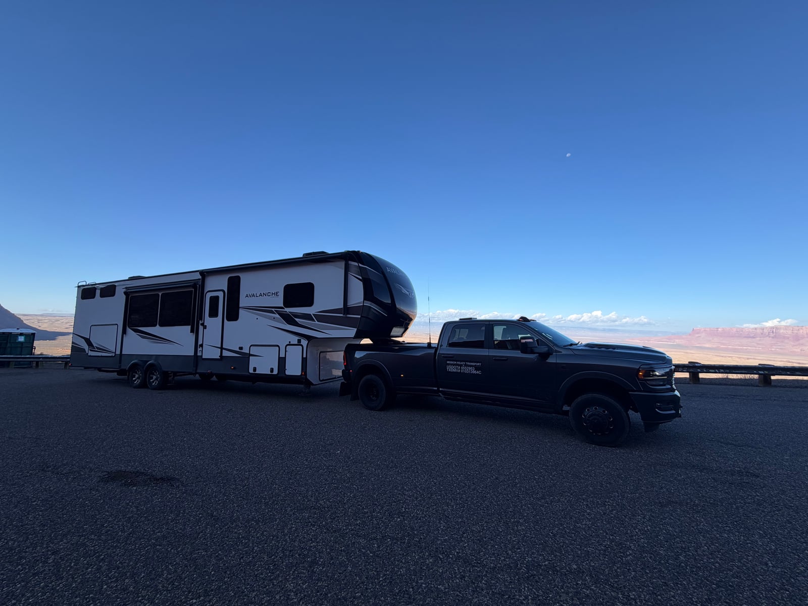Mission Ready Transport truck towing a Keystone Avalanche fifth wheel at a desert overlook