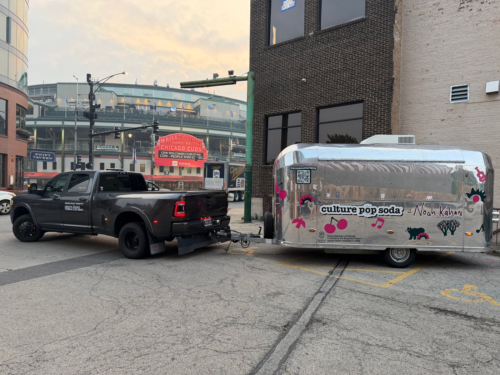 Mission Ready Transport truck towing a polished aluminum vintage-style trailer on a city street