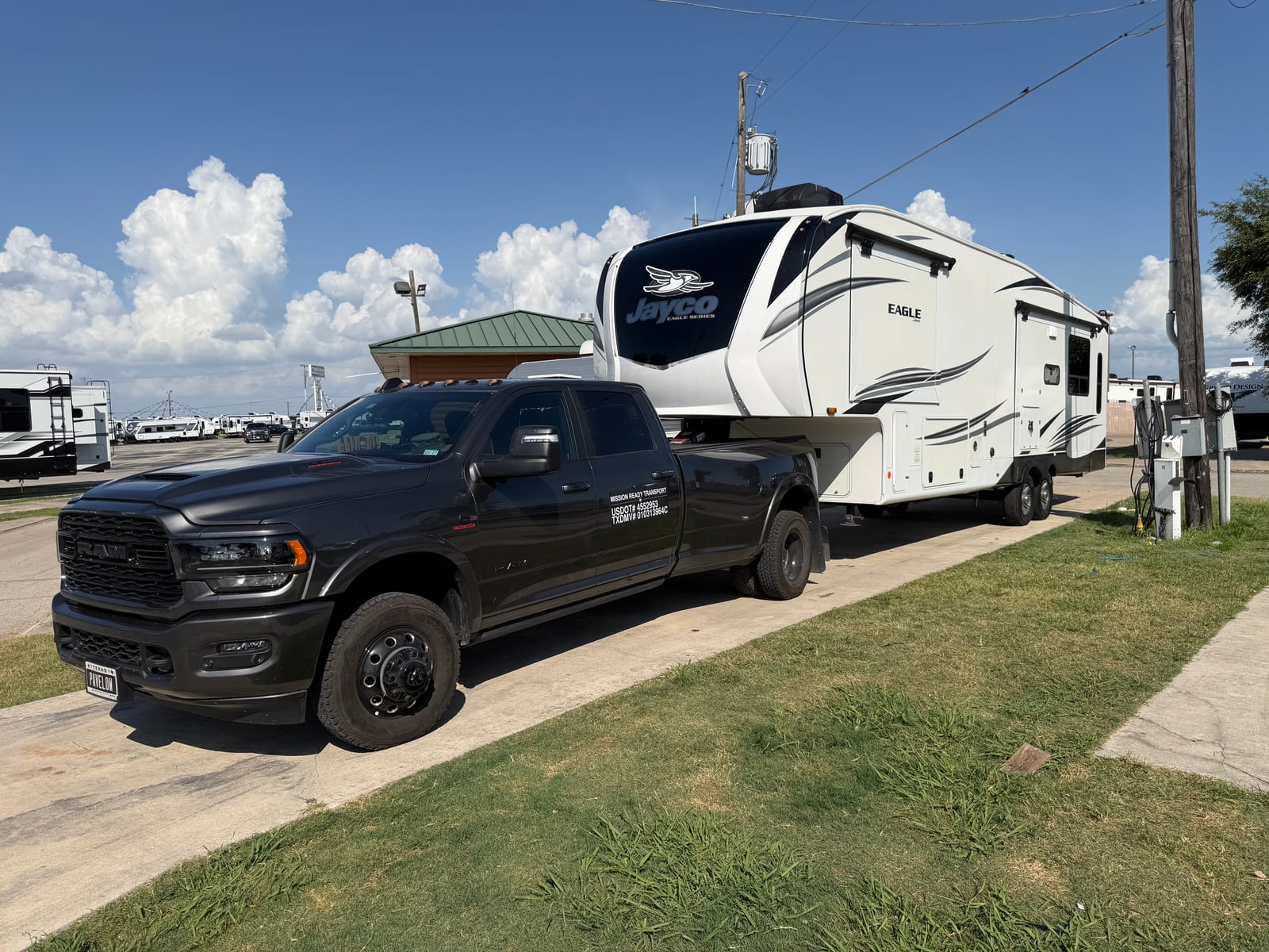 Mission Ready Transport truck towing a Jayco Eagle fifth wheel at an RV park