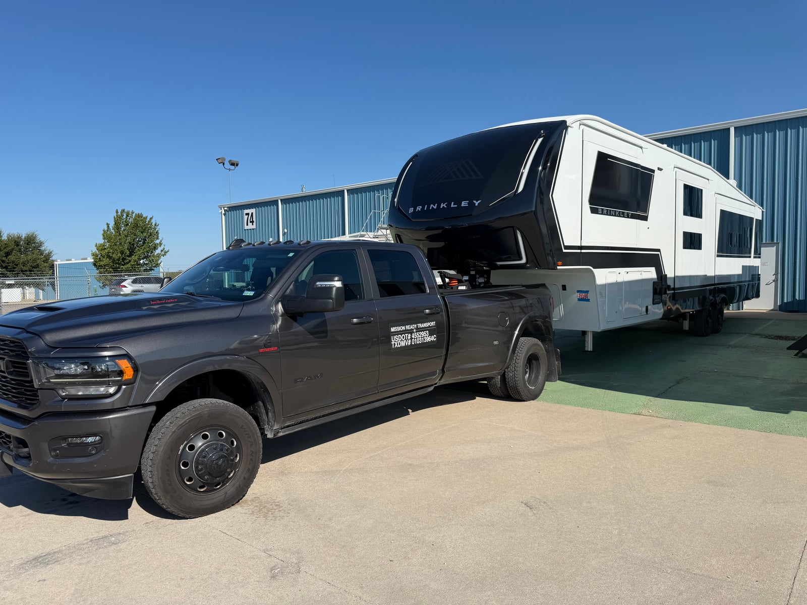Mission Ready Transport truck towing a Brinkley fifth wheel at a storage lot