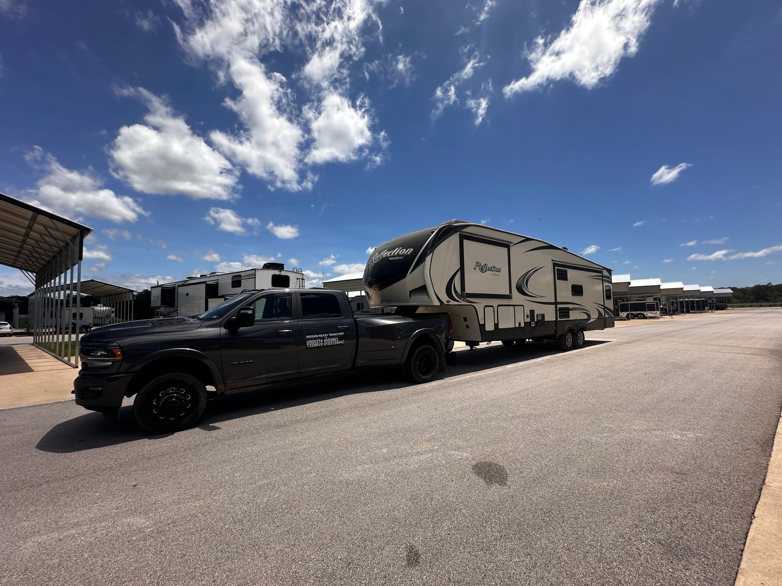 Mission Ready Transport truck hitched to a Grand Design Reflection fifth wheel at an RV storage facility