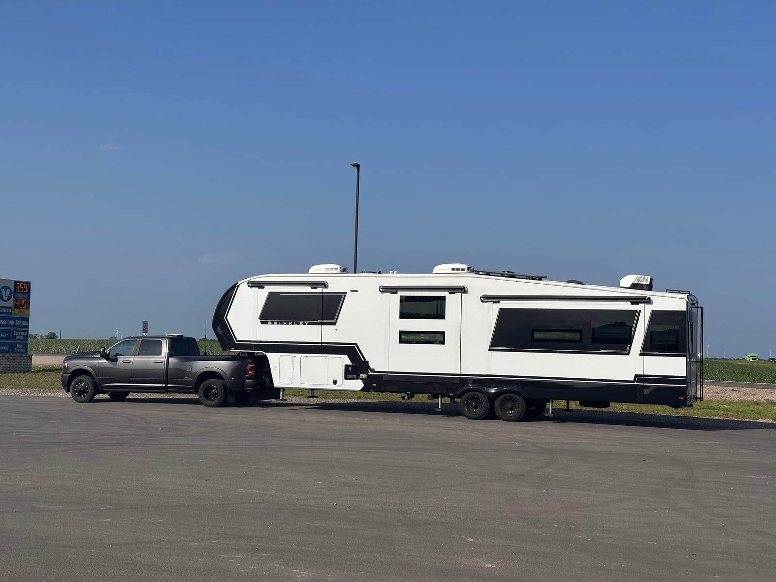 Mission Ready Transport truck towing a large fifth wheel across an open parking area